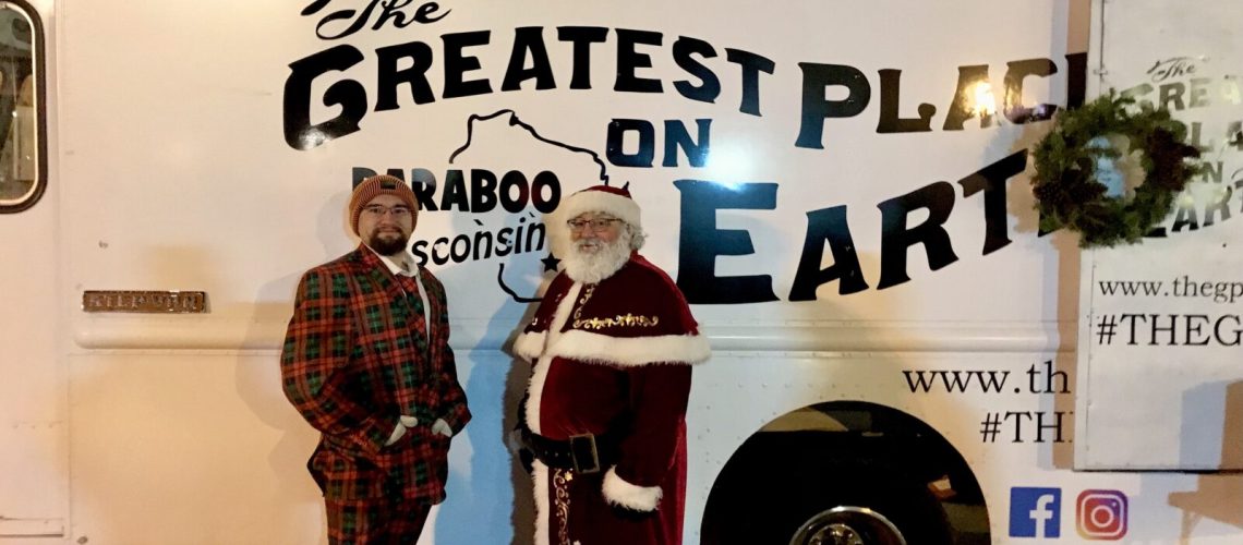 Community member in Baraboo with a GPOE Ambassador and Santa in front of The Greatest Place On Earth Baraboo truck.